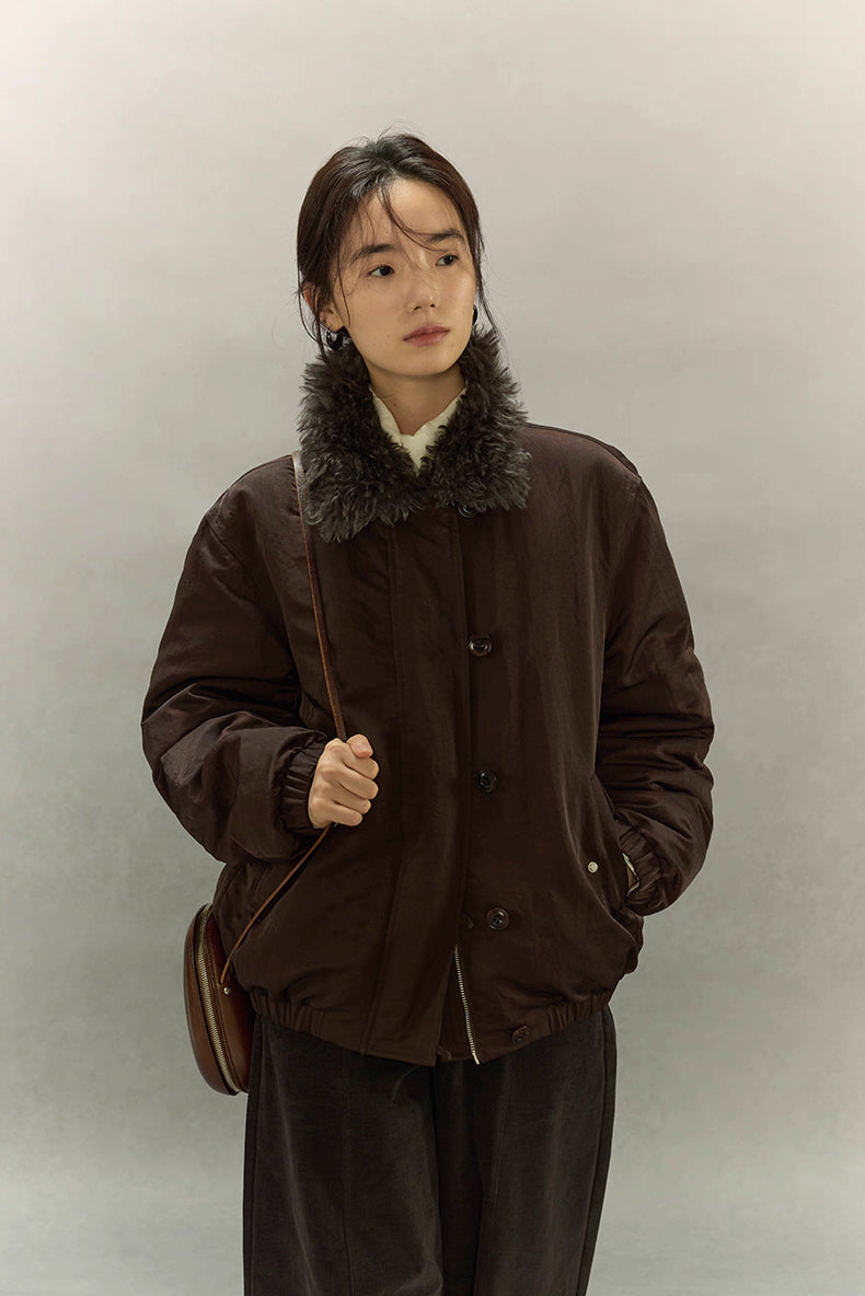 Front close-up of model wearing dark coffee brown sherpa-collar down jacket with crossbody bag