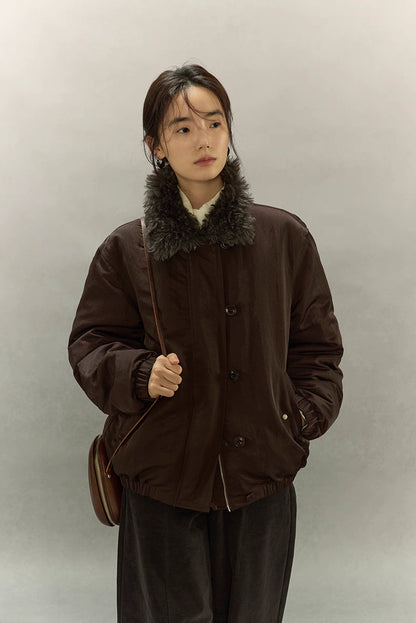 Front close-up of model wearing dark coffee brown sherpa-collar down jacket with crossbody bag