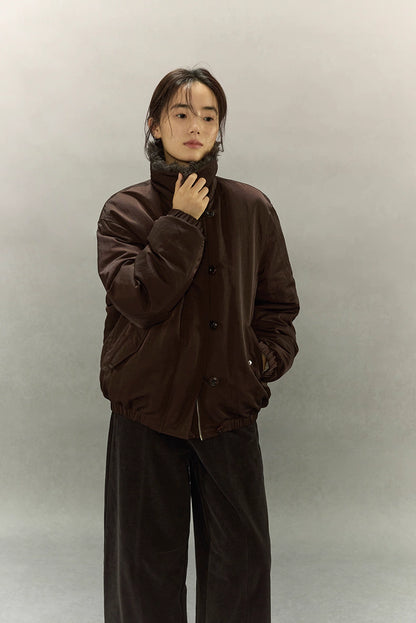 Model wearing dark coffee brown down jacket with sherpa collar turned up for extra warmth