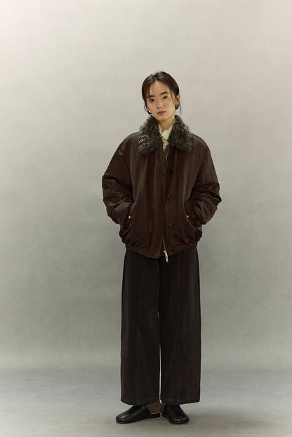Full-body front view of dark coffee brown sherpa-collar down jacket styled with wide-leg pants