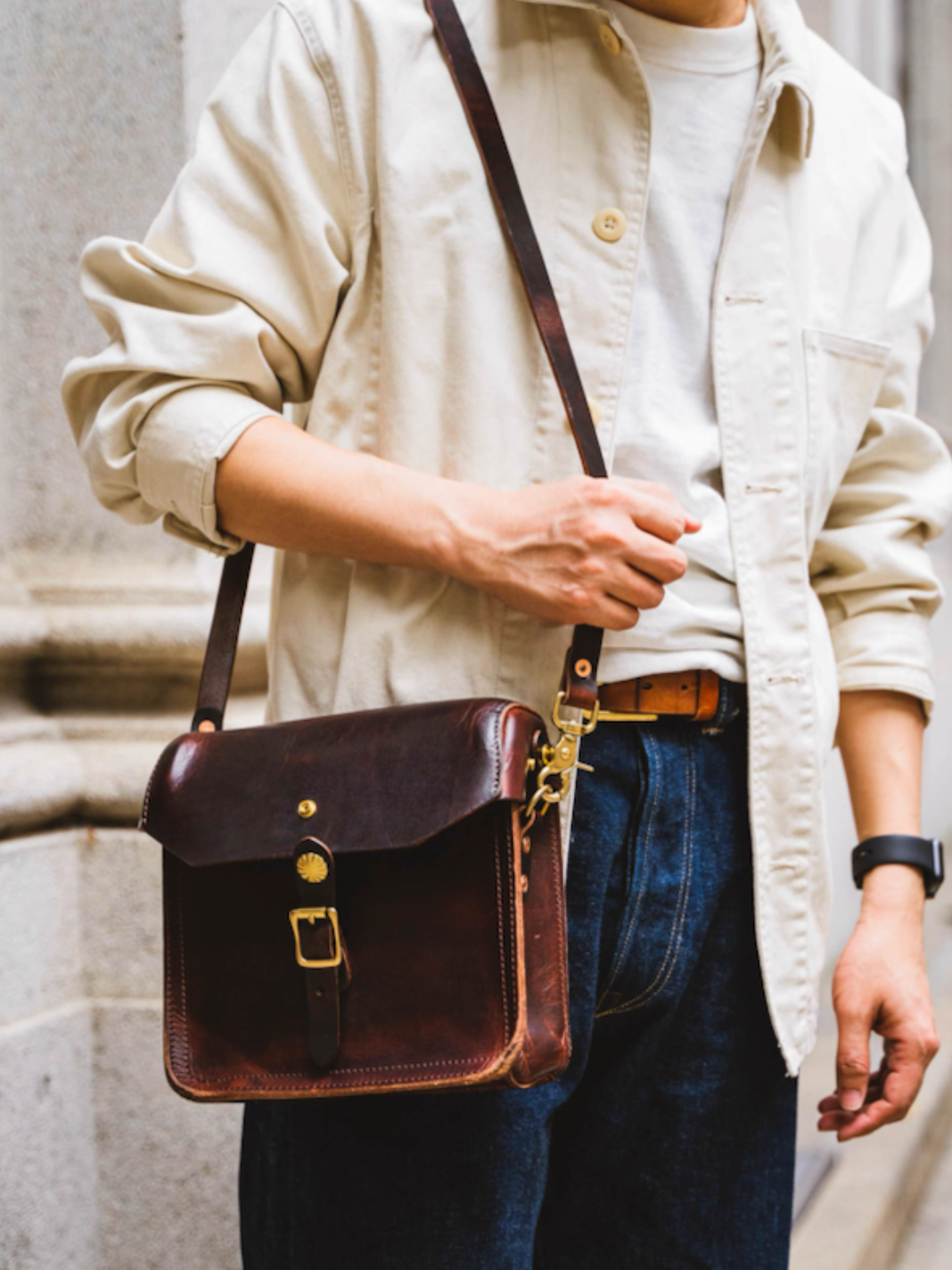 Man wearing dark brown handmade Italian leather crossbody satchel on city street