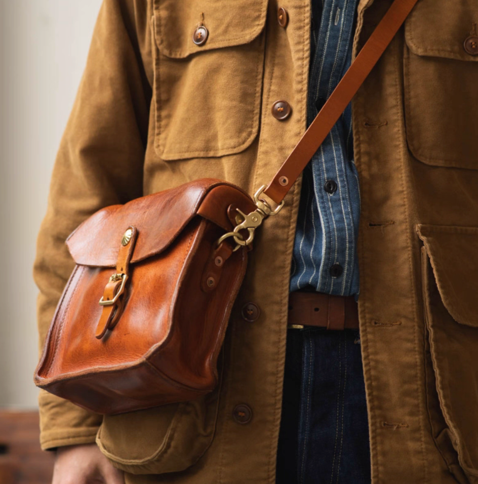 Man wearing light brown full-grain Italian leather crossbody bag with brass hardware