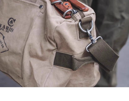 Close-up of khaki waxed canvas bag with metal hardware and strap detail