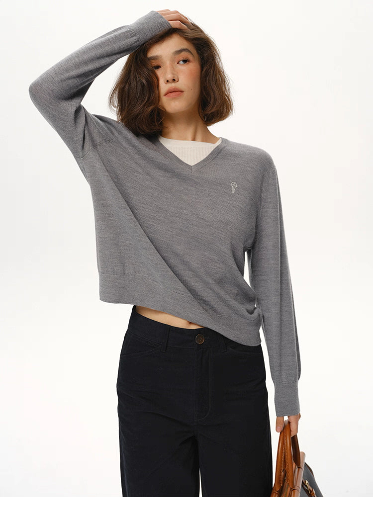 Heather Gray merino wool V-neck sweater styled with black trousers, relaxed pose