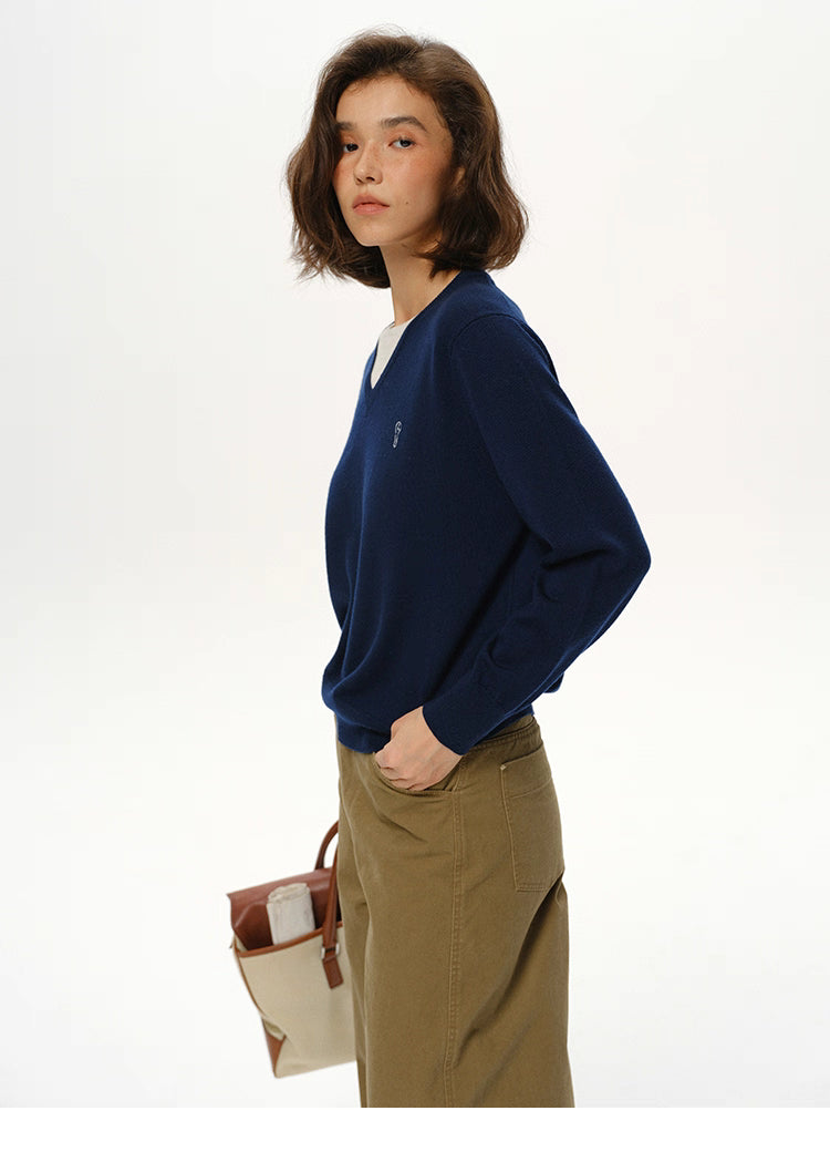 Side profile of Navy Blue wool V-neck sweater paired with neutral trousers