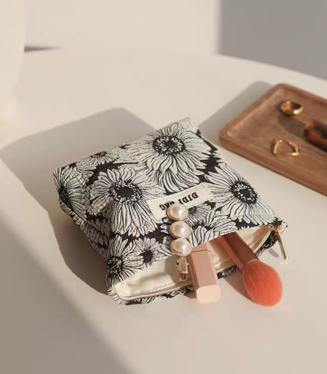 Daisy Daisy Travel Makeup Bag open with makeup items inside showing interior space and zipper closure