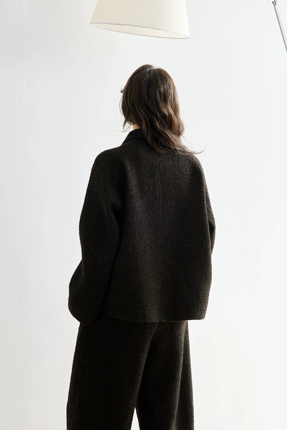 Back view of a Dark Brown bouclé jacket and cropped pant set showing raglan sleeves and center back seam