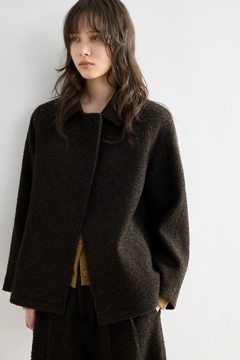 Front view of a Dark Brown bouclé jacket with small collar and minimal front closure