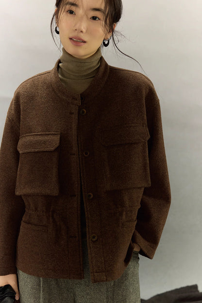 Three-quarter front view of woman in dark coffee alpaca wool field jacket over olive turtleneck