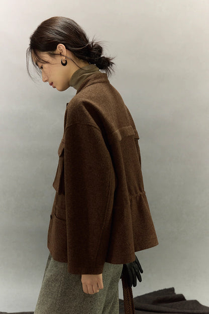 Side profile of woman wearing dark coffee alpaca wool field jacket highlighting textured tweed fabric