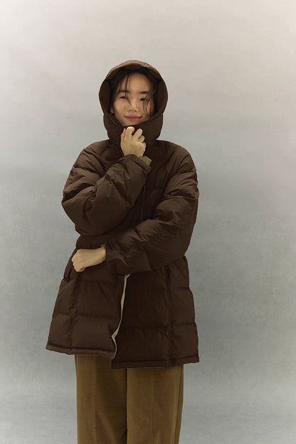 Cozy winter styling of dark coffee brown goose down coat with hood fully up