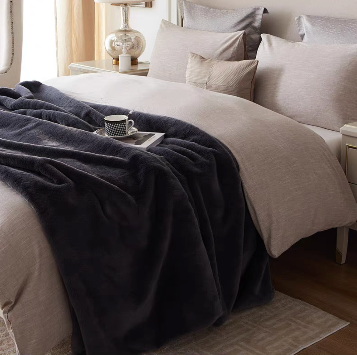 Dark gray faux fur throw blanket styled on bed creating a warm and inviting bedroom look