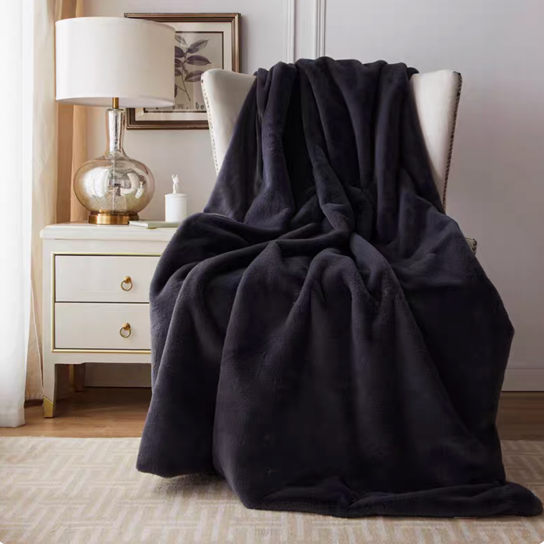 Dark gray plush faux fur throw blanket draped over chair adding cozy modern home decor style
