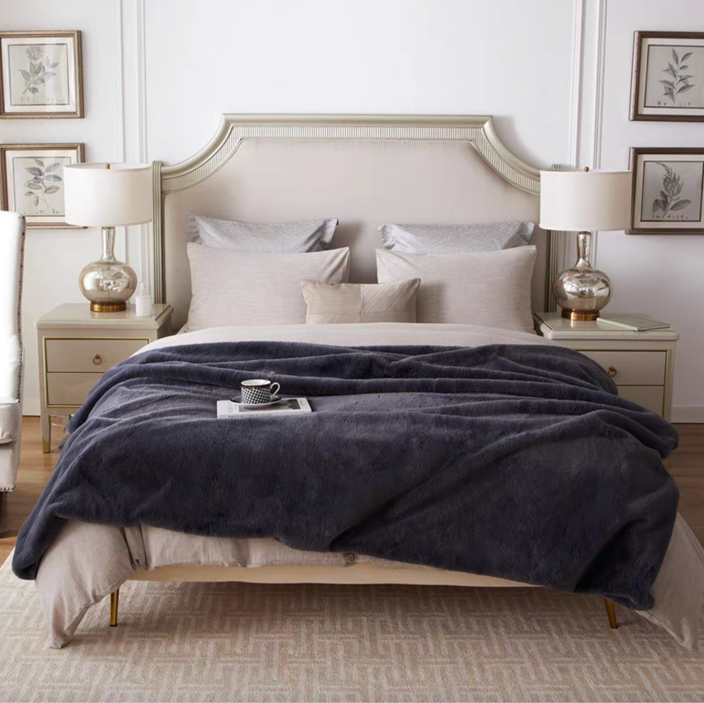 Dark gray reversible faux fur throw blanket spread across full bed for elegant bedroom styling