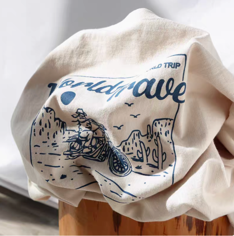 Desert Rider Graphic Cotton Tee Cream White folded view showing motorcycle desert graphic print and soft cotton fabric