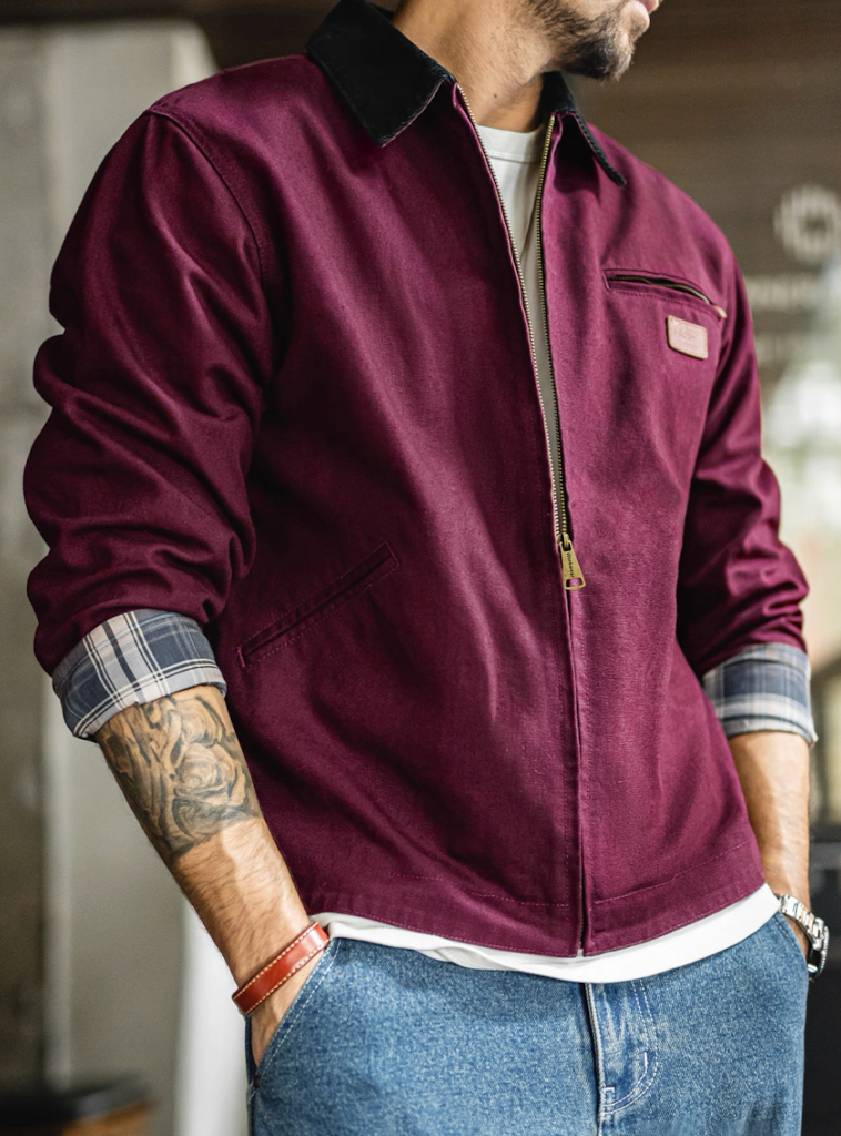 Man wearing burgundy Detroit work jacket with rolled sleeves