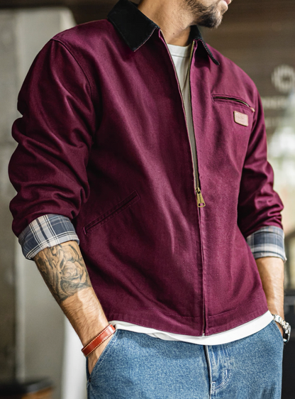 Man wearing burgundy Detroit work jacket with rolled sleeves