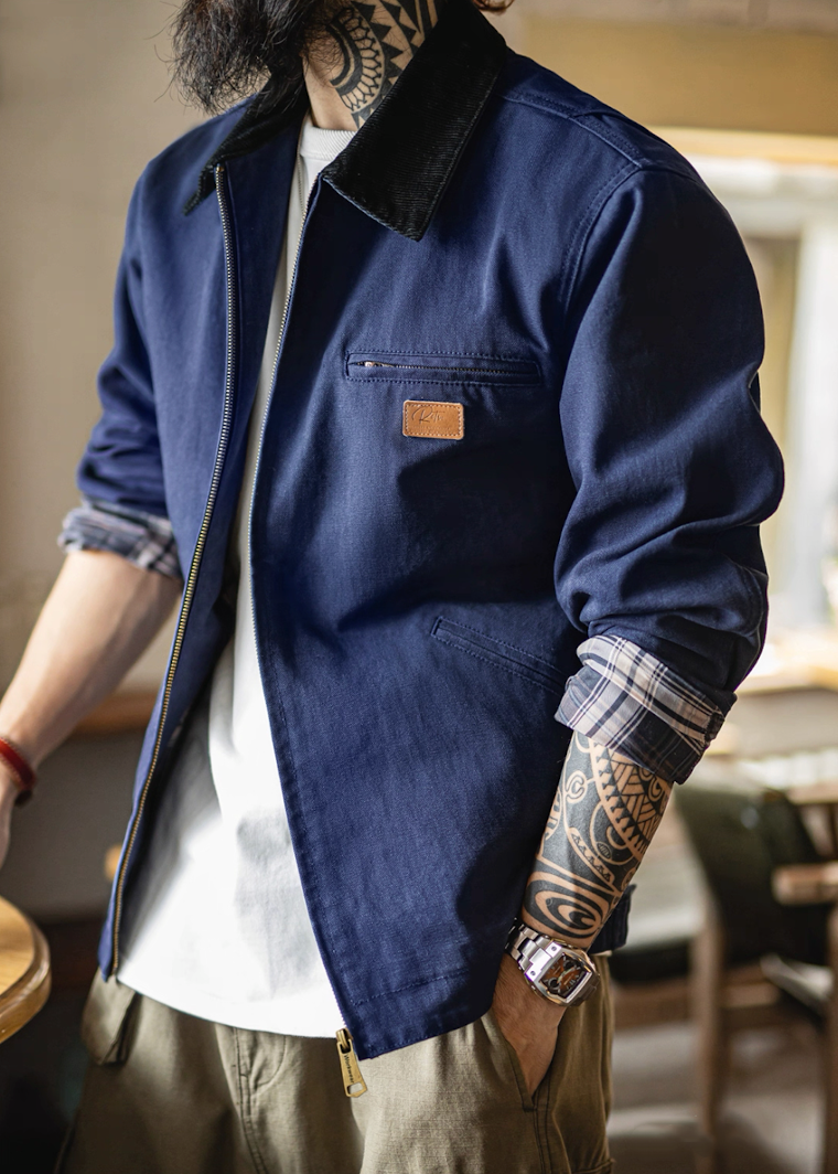 Man wearing navy Detroit work jacket with white shirt and tattoos