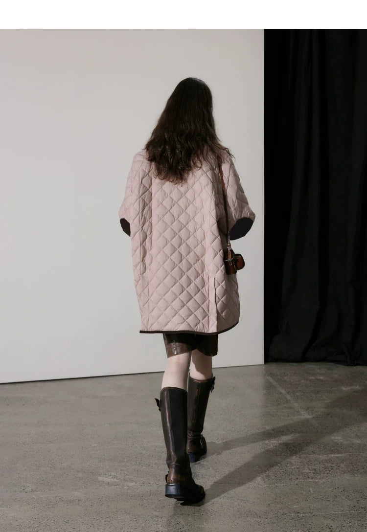 Back view of pink quilted down coat showing brown corduroy elbow patches and piped hem
