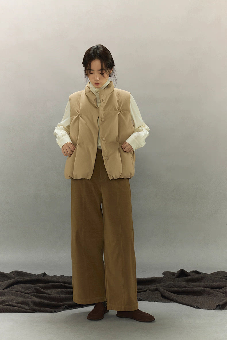 full-body outfit featuring beige lightweight down vest with brown pants