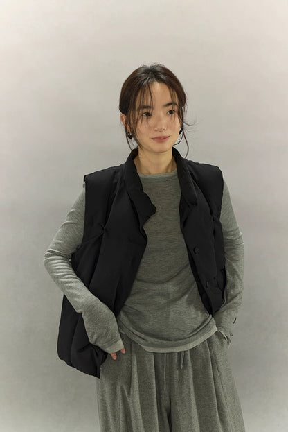 woman in black minimalist down vest with hands in pockets front view
