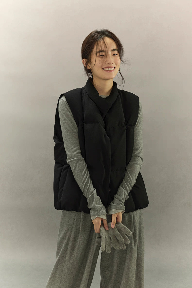 woman wearing black sculpted down vest smiling in front view