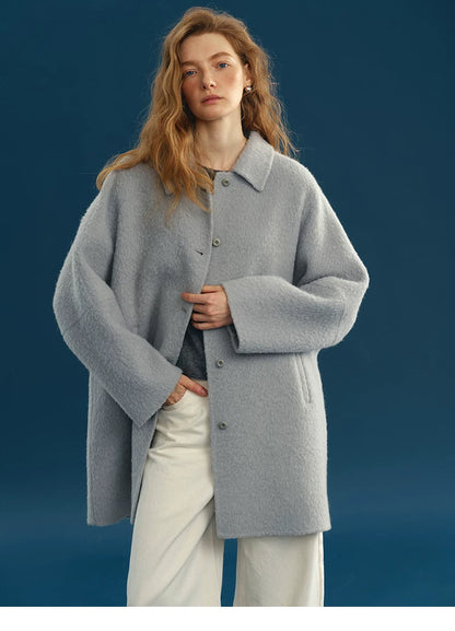 Front view of a Dusty Blue oversized wool coat with point collar, tonal buttons, and welt pockets