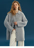 Front view of a Dusty Blue oversized wool coat with point collar, tonal buttons, and welt pockets