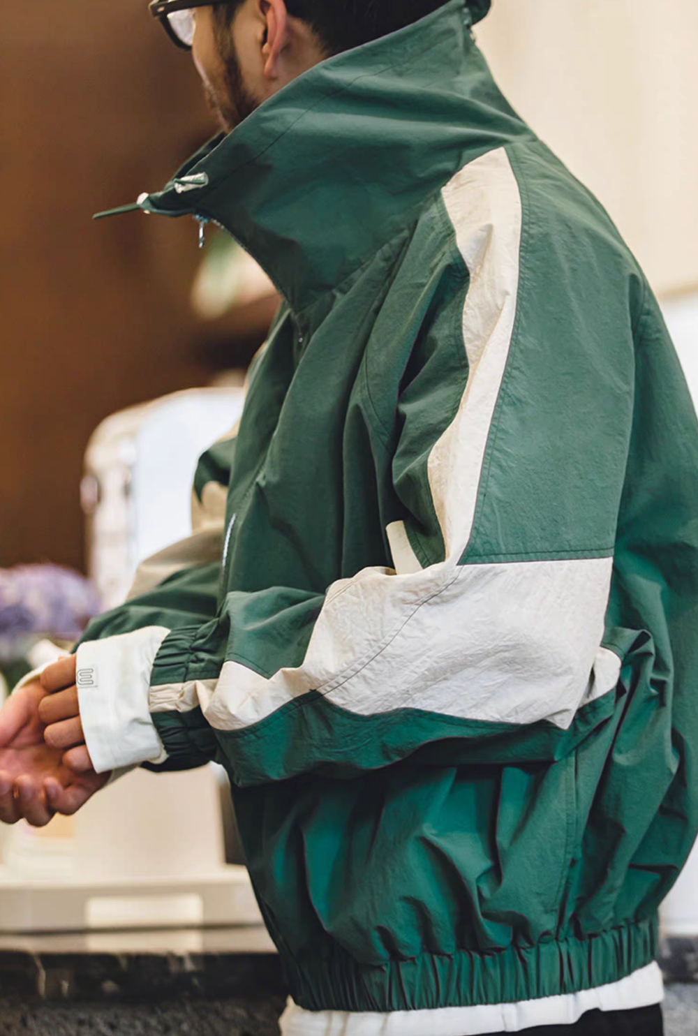 Back side view of Arden Green Dynamic Layering Jacket highlighting contrasting sleeve panel and relaxed fit silhouette