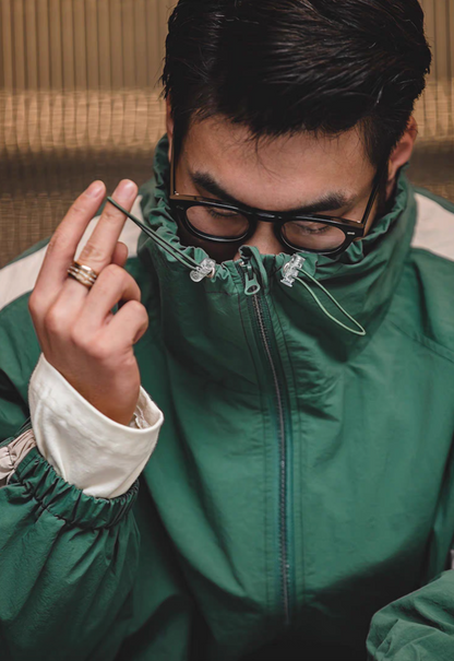 Close-up of Arden Green Dynamic Layering Jacket showing adjustable drawstring collar and zipper closure detail