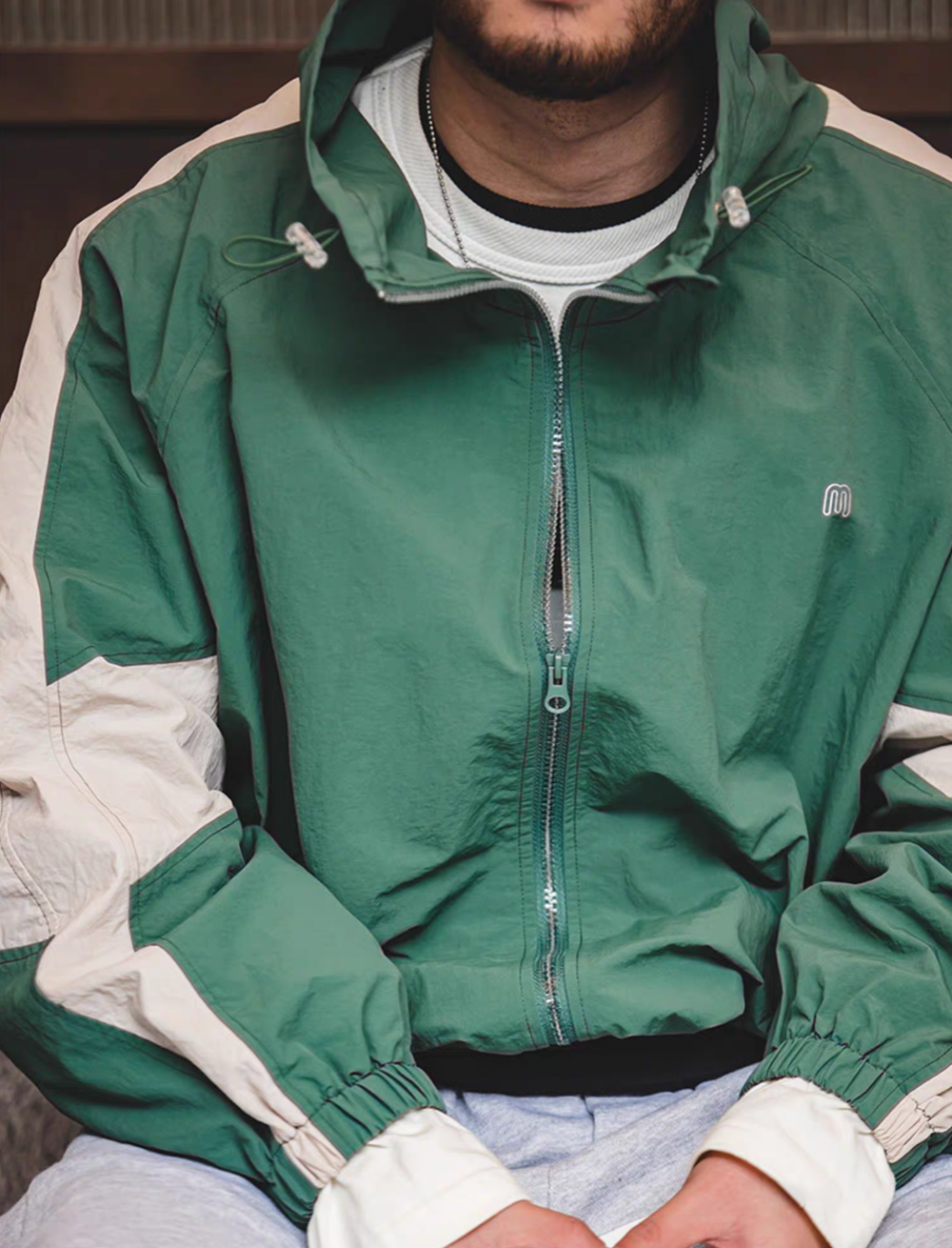 Man wearing Arden Green Dynamic Layering Jacket front view highlighting dual zipper design and lightweight nylon fabric