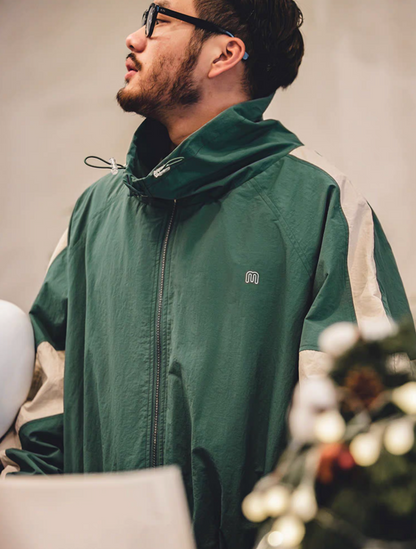 Side profile of Arden Green Dynamic Layering Jacket worn by model showing structured collar and color block sleeve detail