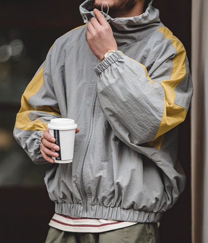 Man wearing Scottish Grey Dynamic Layering Jacket holding coffee highlighting lightweight fabric and relaxed fit