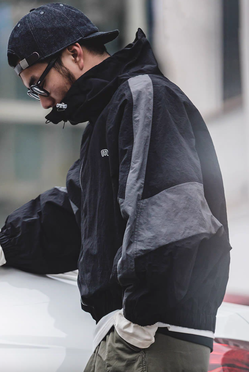 Side view of Sumatra Black Dynamic Layering Jacket worn by model highlighting color block sleeve and urban styling