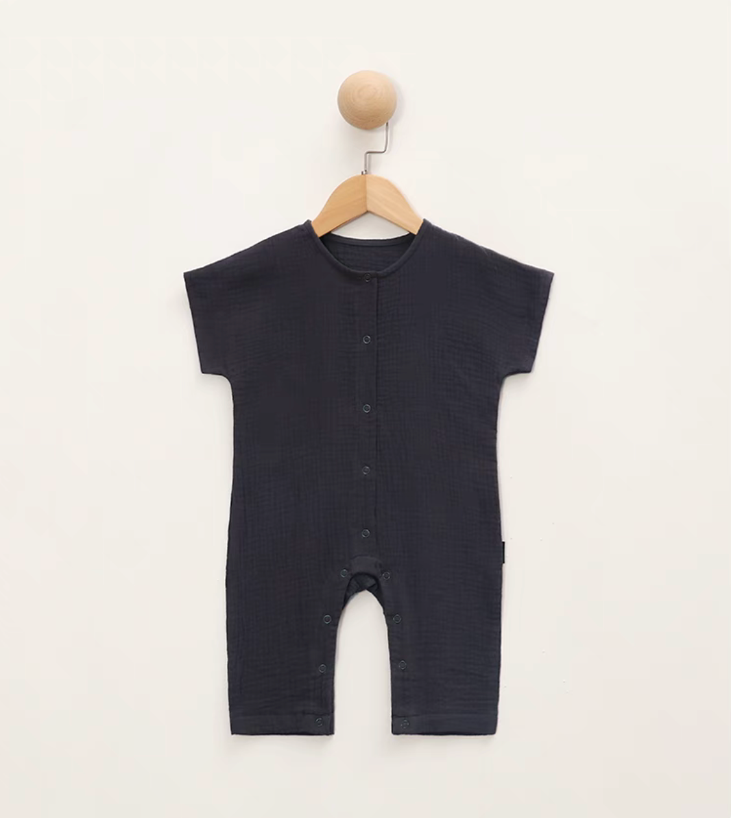 Charcoal gray short sleeve baby romper hanging on wooden hanger front view