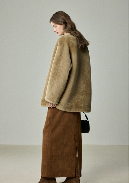 Back side view of relaxed camel shearling jacket over a long suede skirt