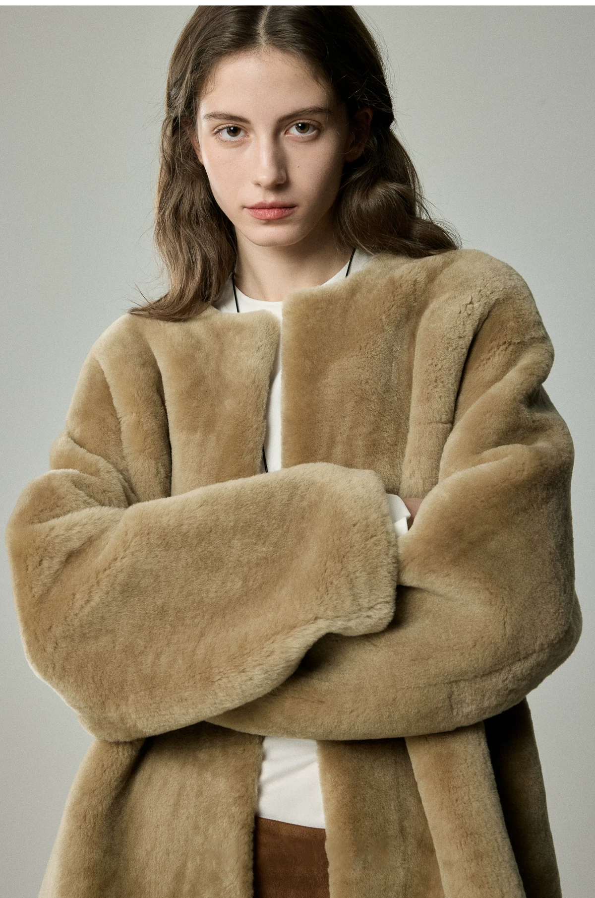 Close view of camel shearling jacket with wide plush sleeves and round neckline