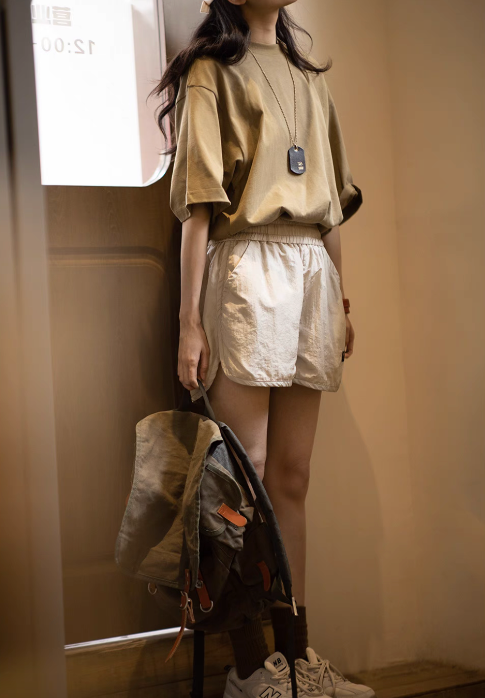 Effortless Sport Shorts off-white worn with relaxed outfit and backpack in indoor lifestyle scene
