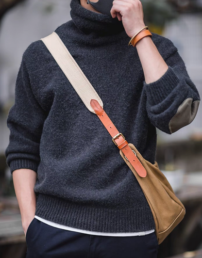 Man wearing Elbow Patch Turtleneck Sweater in charcoal black with crossbody bag featuring foldable turtleneck and relaxed fit silhouette