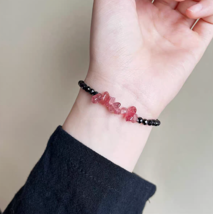 Strawberry quartz and black spinel bracelet worn on wrist showing delicate pink crystal bead centerpiece