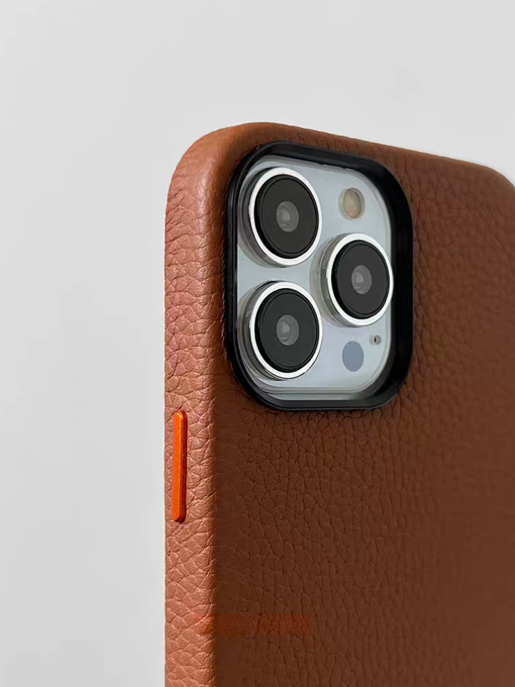 Close-up of brown leather MagSafe phone case showing raised camera protection and textured finish