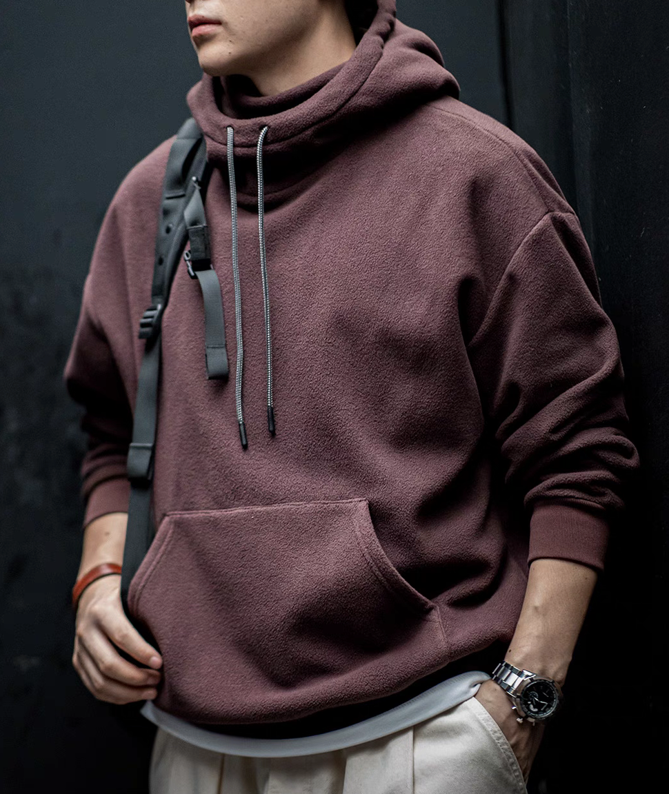 Elevate Shield Hoodie in chestnut red worn casually with backpack featuring soft fleece fabric and functional streetwear style