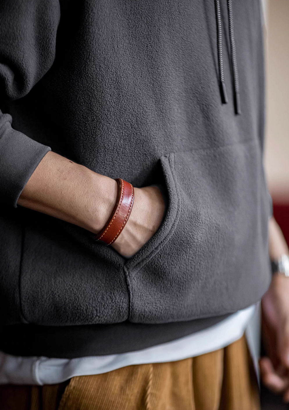 Close-up of Elevate Shield Hoodie in dark gray showing soft fleece fabric and kangaroo pocket for warmth and everyday use