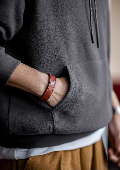 Close-up of Elevate Shield Hoodie in dark gray showing soft fleece fabric and kangaroo pocket for warmth and everyday use