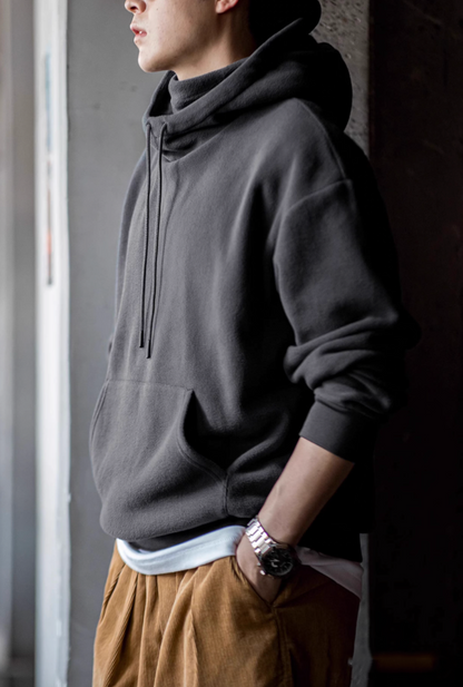 Side profile of Elevate Shield Hoodie in dark gray highlighting relaxed straight fit, ribbed cuffs, and cozy fleece construction