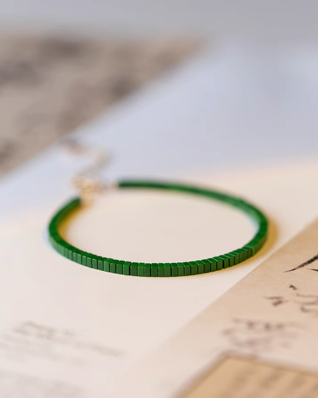 Moss green minimalist malachite bracelet shown at an angle highlighting flat bead alignment and texture