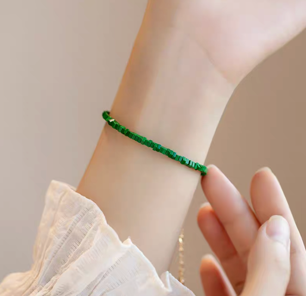 Moss green flat bead malachite bracelet worn on wrist showing minimalist and elegant styling