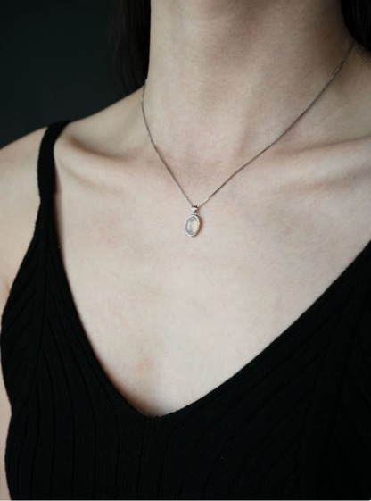 Model wearing Ethereal Elegance Gray Agate Necklace with oval gray agate pendant on silver chain
