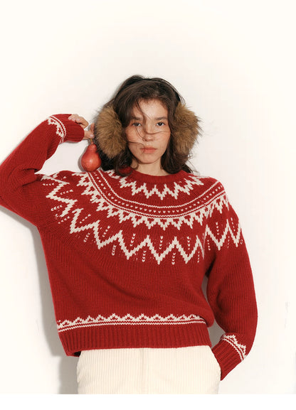 Woman wearing red and cream Fair Isle merino wool sweater with arms outstretched against a white background.