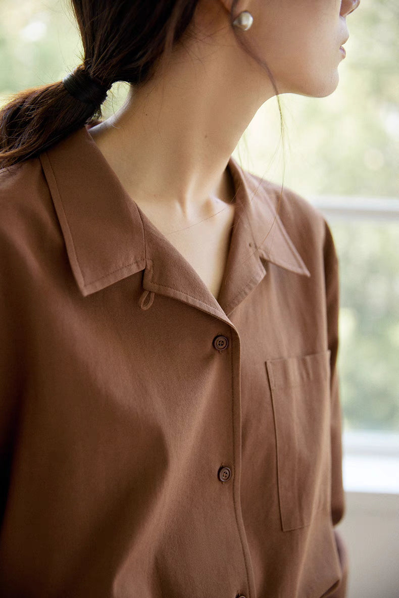 Close-up of brown long-staple cotton shirt showing spread collar, bamboo button detail, and smooth enzyme-washed texture